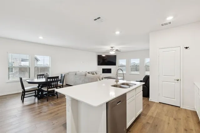 a kitchen with a sink a stove a refrigerator a dining table and chairs