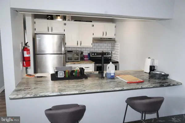 a kitchen with granite countertop a sink appliances and cabinets