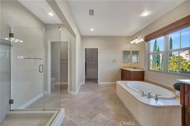 a bathroom with a tub sink shower and mirror