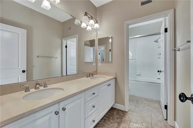 a bathroom with a sink double vanity granite tub and shower