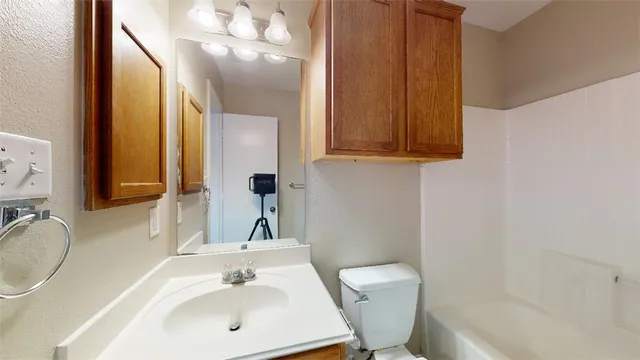 a bathroom with a sink a toilet and mirror