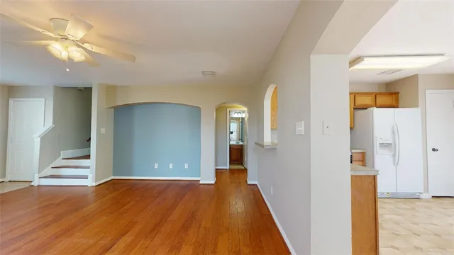 a view of a hallway with wooden floor and a living room
