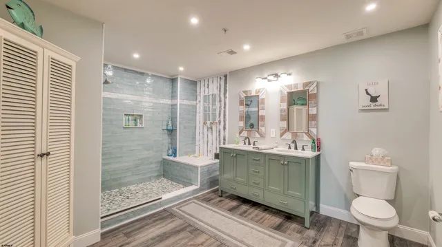 a bathroom with a granite countertop sink a toilet and shower