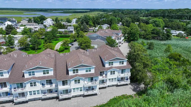 an aerial view of residential houses with outdoor space and trees
