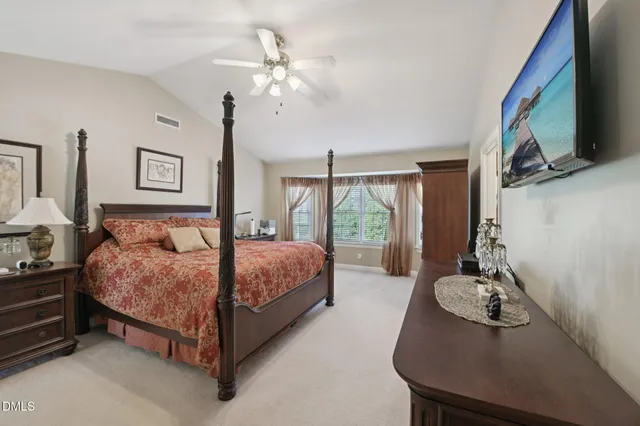 a bedroom with a large bed and a chandelier