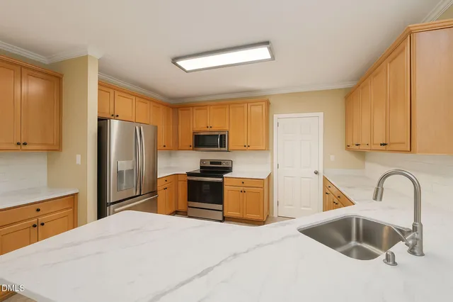 a kitchen with white cabinets and stainless steel appliances
