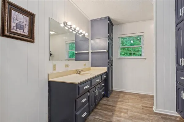 a bathroom with a sink a large mirror and a window