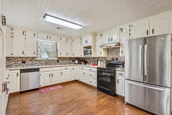 a kitchen with granite countertop stainless steel appliances and wooden cabinets