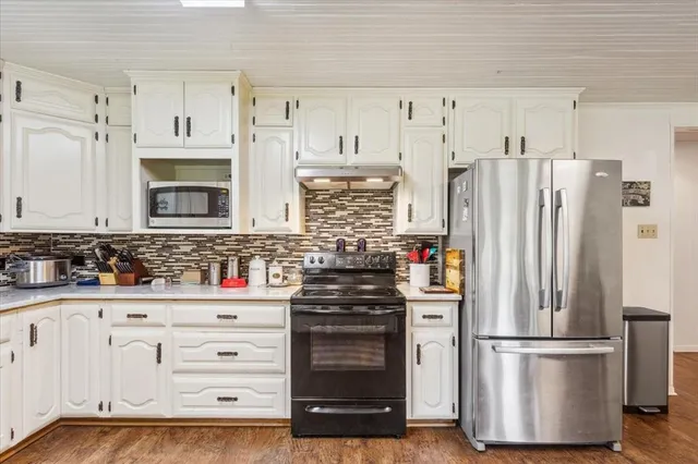 a kitchen with refrigerator a stove and cabinets