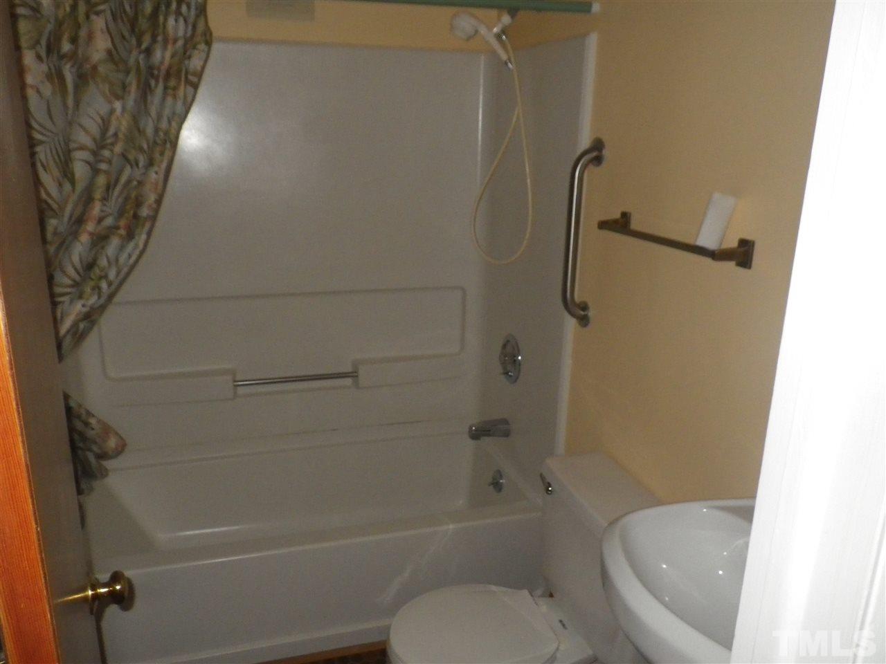 5024 Wickham Road Raleigh, NC 27606 - Photo 8 of 14 a bathroom with a toilet and a shower