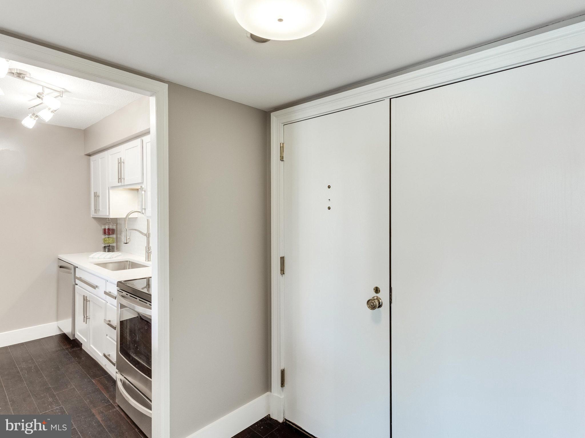 1301 North Courthouse Road, Unit 1411 Arlington, VA 22201 - Photo 2 of 30 a view of a kitchen with white cabinets and wooden floor