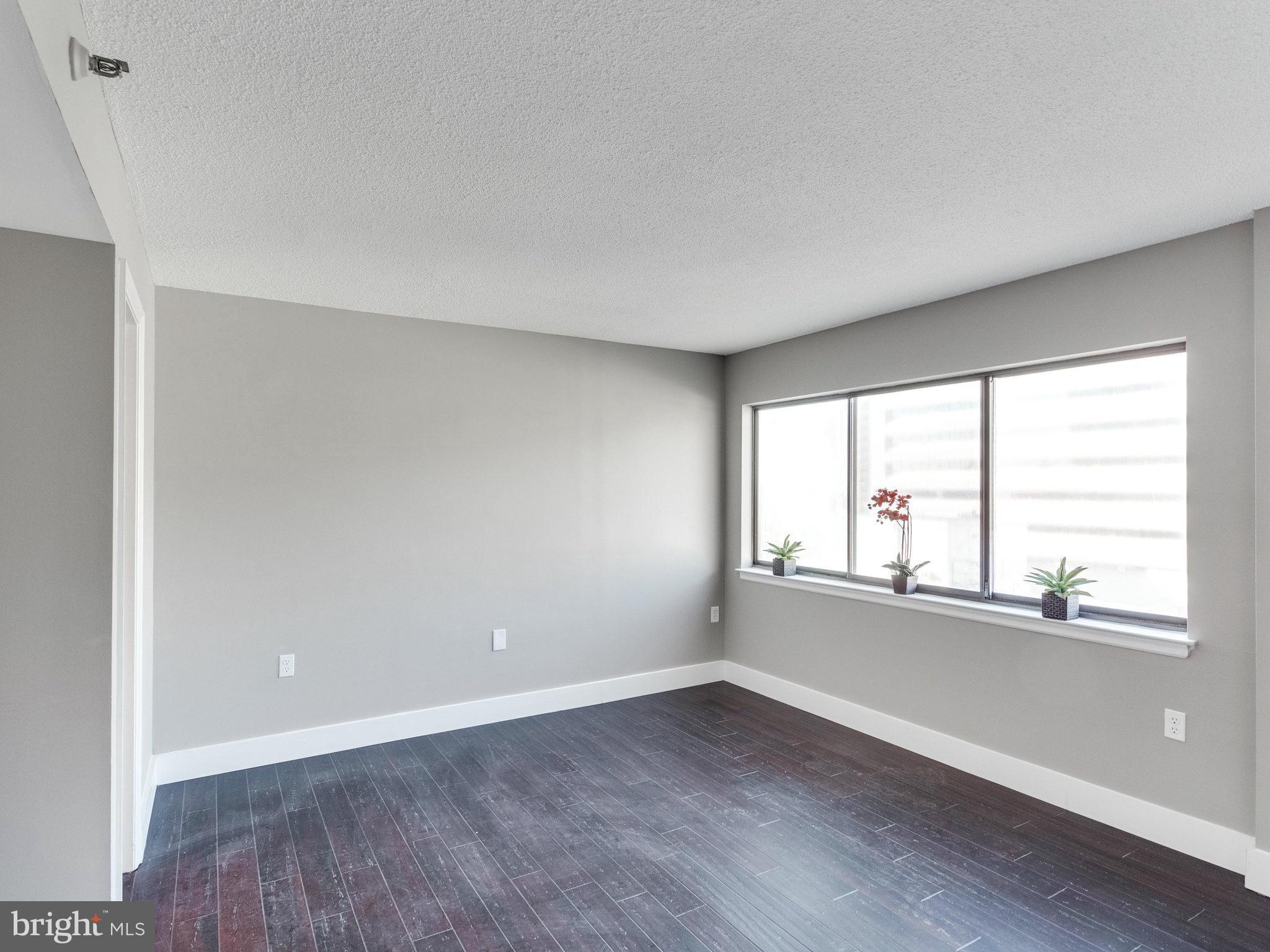1301 North Courthouse Road, Unit 1411 Arlington, VA 22201 - Photo 17 of 30 an empty room with wooden floor and windows