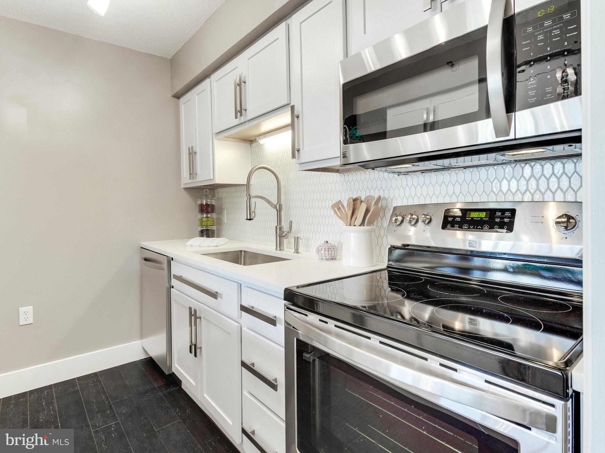 1301 North Courthouse Road, Unit 1411 Arlington, VA 22201 - Photo 4 of 30 a kitchen with a stove and a microwave