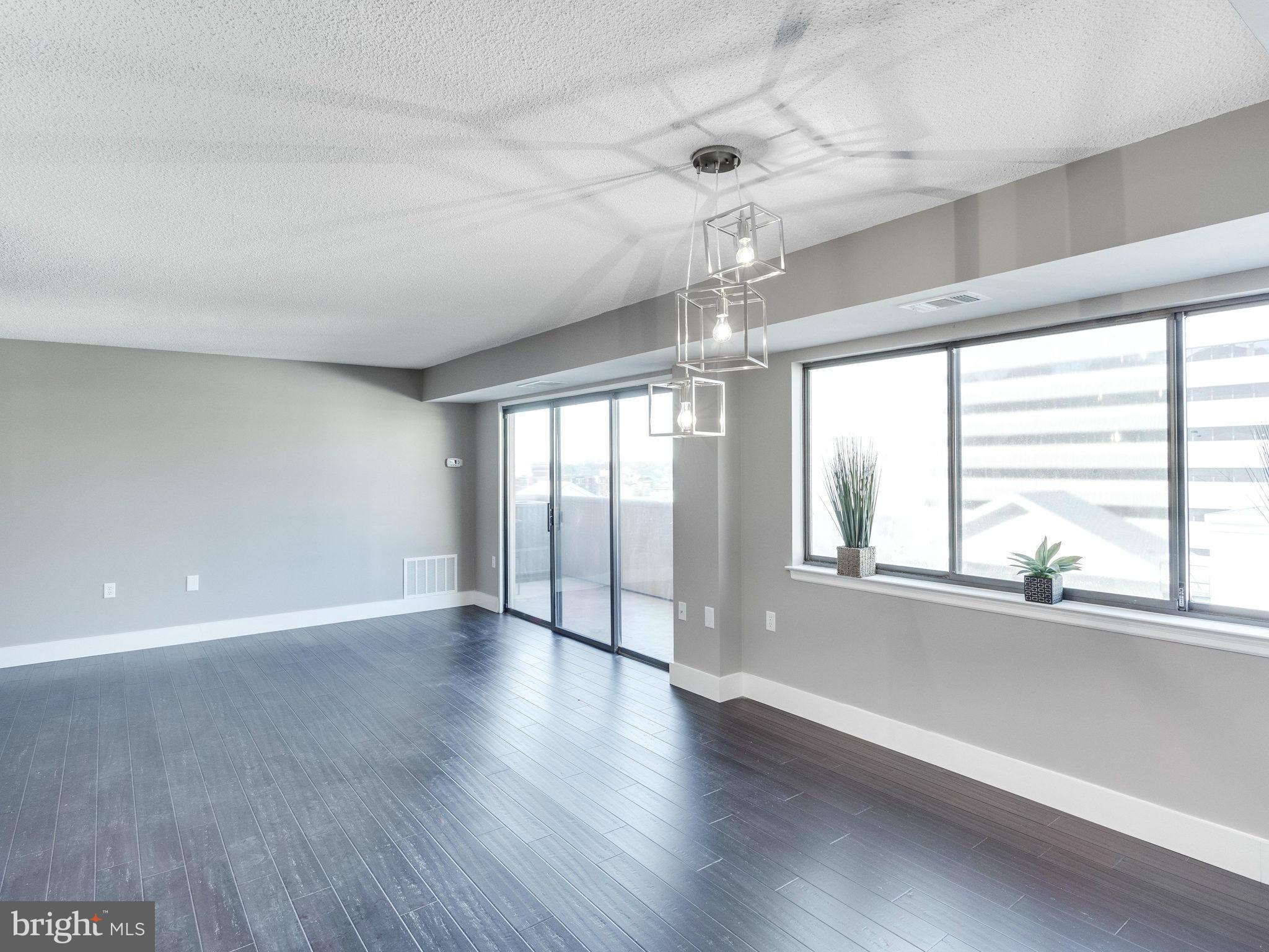 1301 North Courthouse Road, Unit 1411 Arlington, VA 22201 - Photo 10 of 30 a view of an empty room with wooden floor and a window