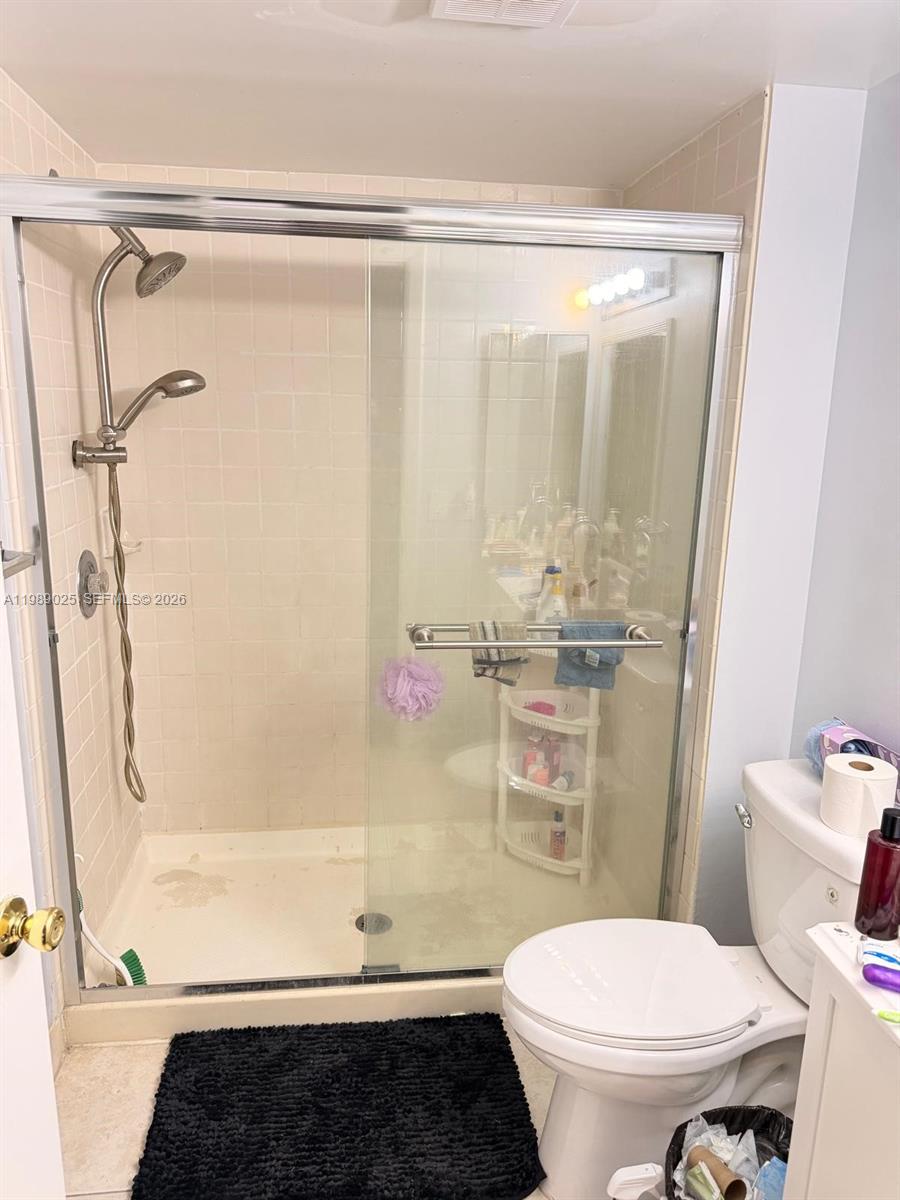 8821 Wiles Road, Unit 108 Coral Springs, FL 33067 - Photo 18 of 46 a bathroom with a shower a toilet and a shower