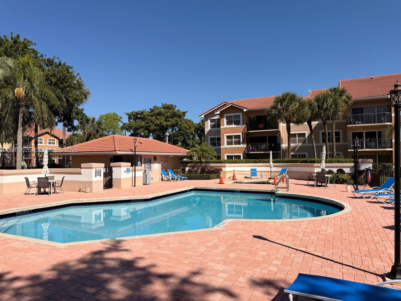 8821 Wiles Road, Unit 108 Coral Springs, FL 33067 - Photo 25 of 46 a view of a swimming pool with a patio