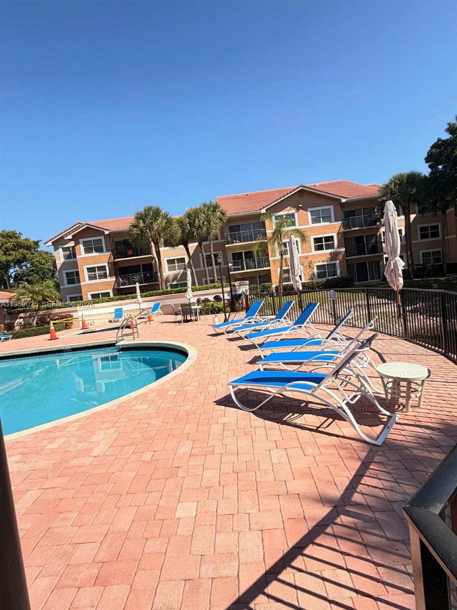 8821 Wiles Road, Unit 108 Coral Springs, FL 33067 - Photo 27 of 46 a view of swimming pool with lounge chairs