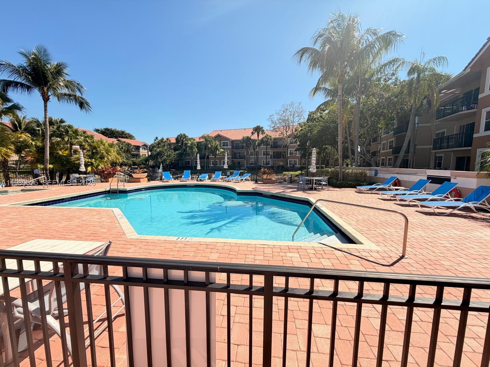 8821 Wiles Road, Unit 108 Coral Springs, FL 33067 - Photo 35 of 46 a view of a swimming pool with a lounge chairs