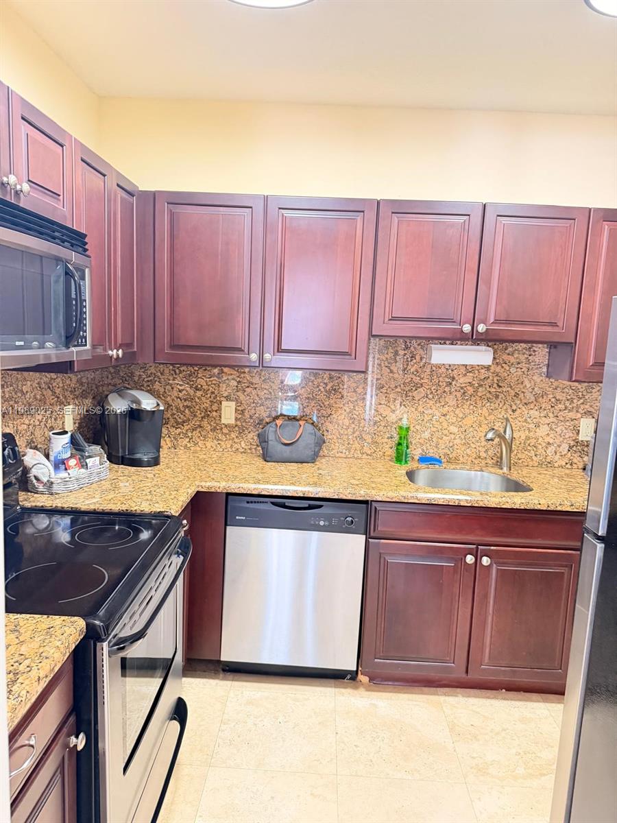 8821 Wiles Road, Unit 108 Coral Springs, FL 33067 - Photo 38 of 46 a kitchen with a sink a stove and cabinets