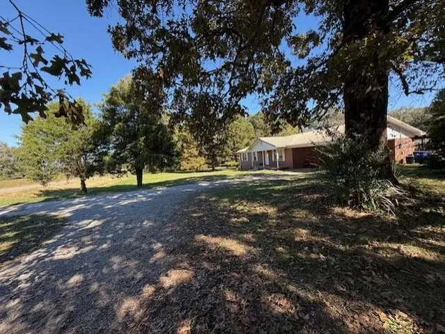 a front view of a house with a garden and trees