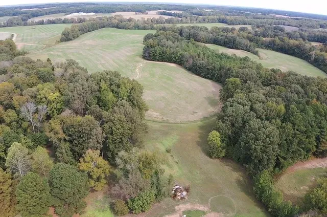 a view of a dry yard with wooden fence