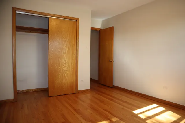 a view of an empty room with closet and a window