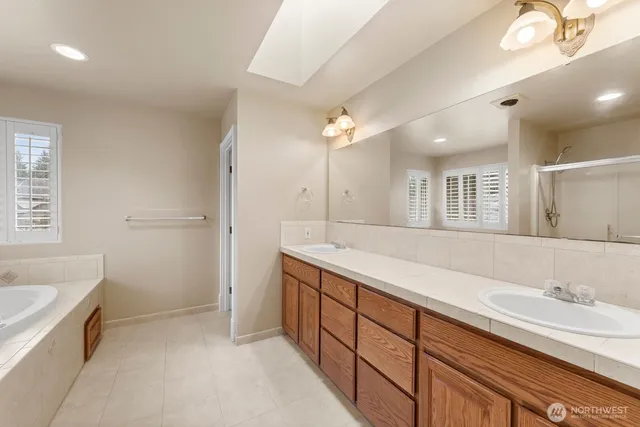 a spacious bathroom with a granite countertop sink mirror and a bathtub