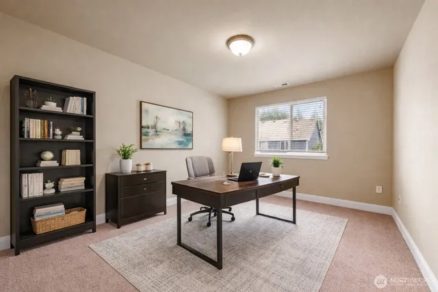 a view of a workspace with furniture and window in a room