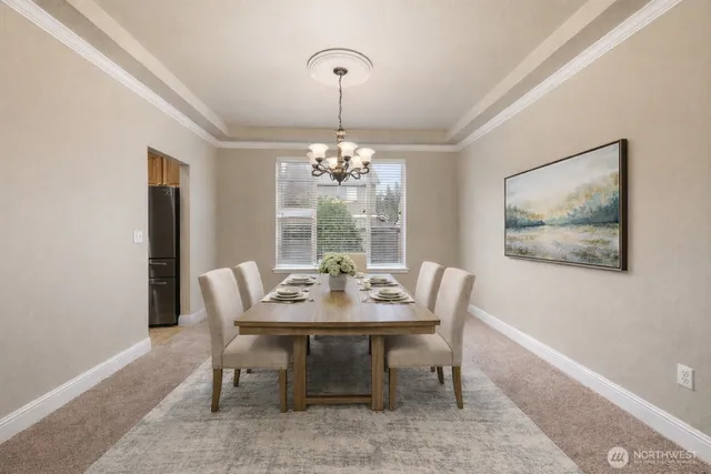 a dining room with furniture a rug and a chandelier