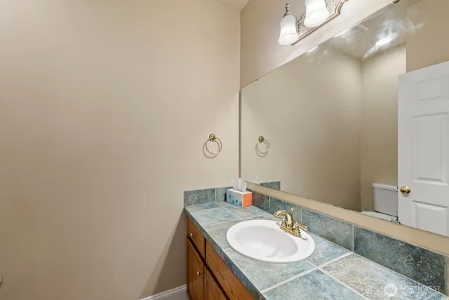a bathroom with a granite countertop sink and a mirror