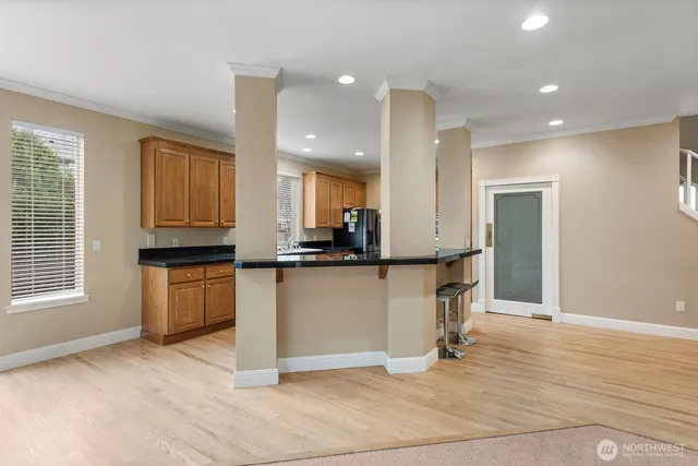 a kitchen with granite countertop a refrigerator and a stove top oven