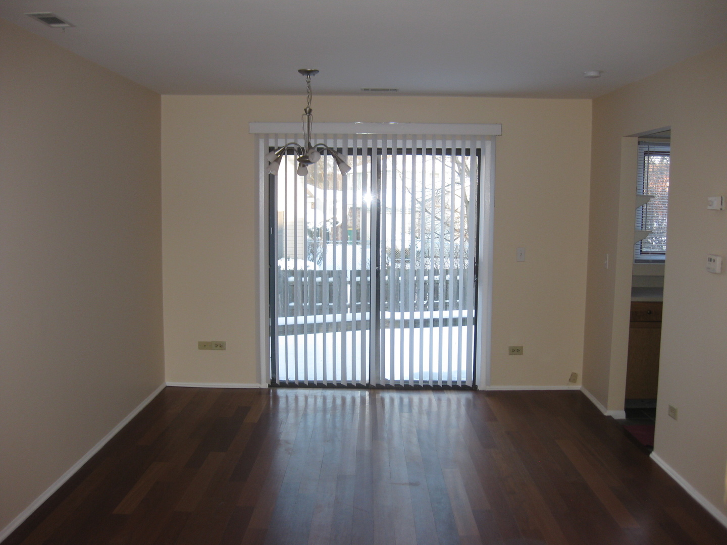 429 Pacific Court Wheeling, IL 60090 - Photo 6 of 16 a view of an empty room with wooden floor and a window