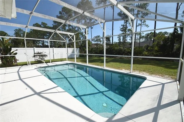 a view of a swimming pool with a patio and a yard