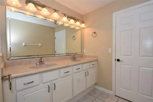 a bathroom with a granite countertop sink a large mirror and a shower
