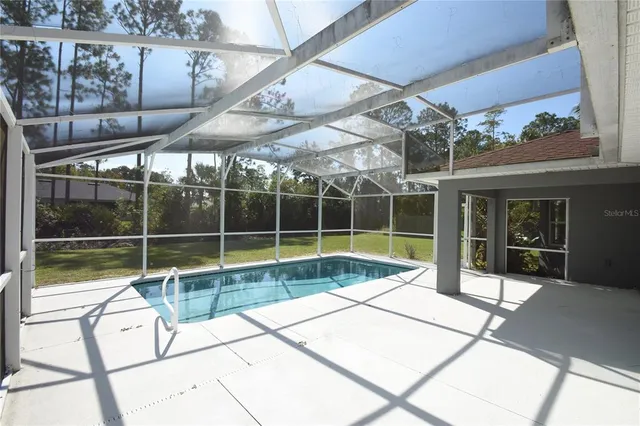 a view of a backyard with a floor to ceiling window and wooden floor