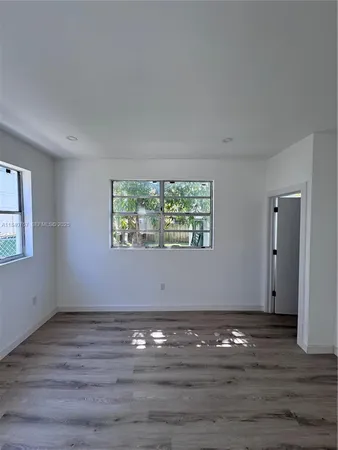 a view of room with window and wooden floor