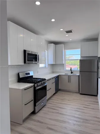a kitchen with stainless steel appliances granite countertop a stove a sink and a refrigerator