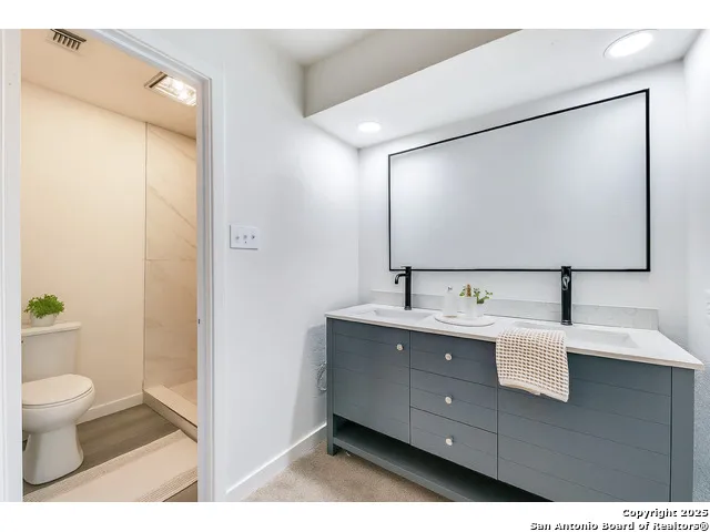 a bathroom with a toilet sink and mirror