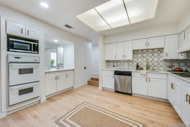 a kitchen with granite countertop cabinets stainless steel appliances and a counter space