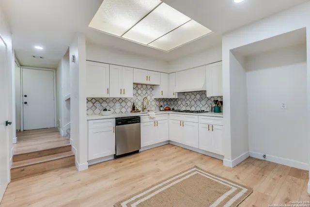 a kitchen with a refrigerator and white cabinets