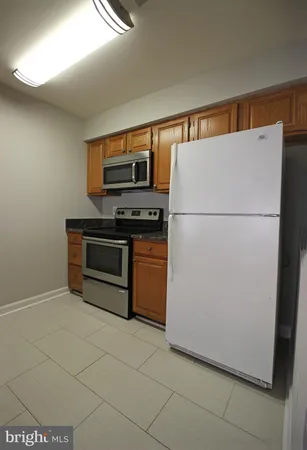 a white refrigerator freezer and a stove sitting inside of a kitchen