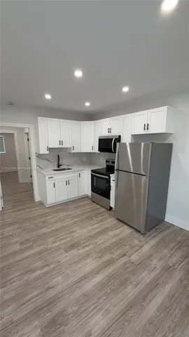 a kitchen with stainless steel appliances granite countertop a refrigerator sink and cabinets