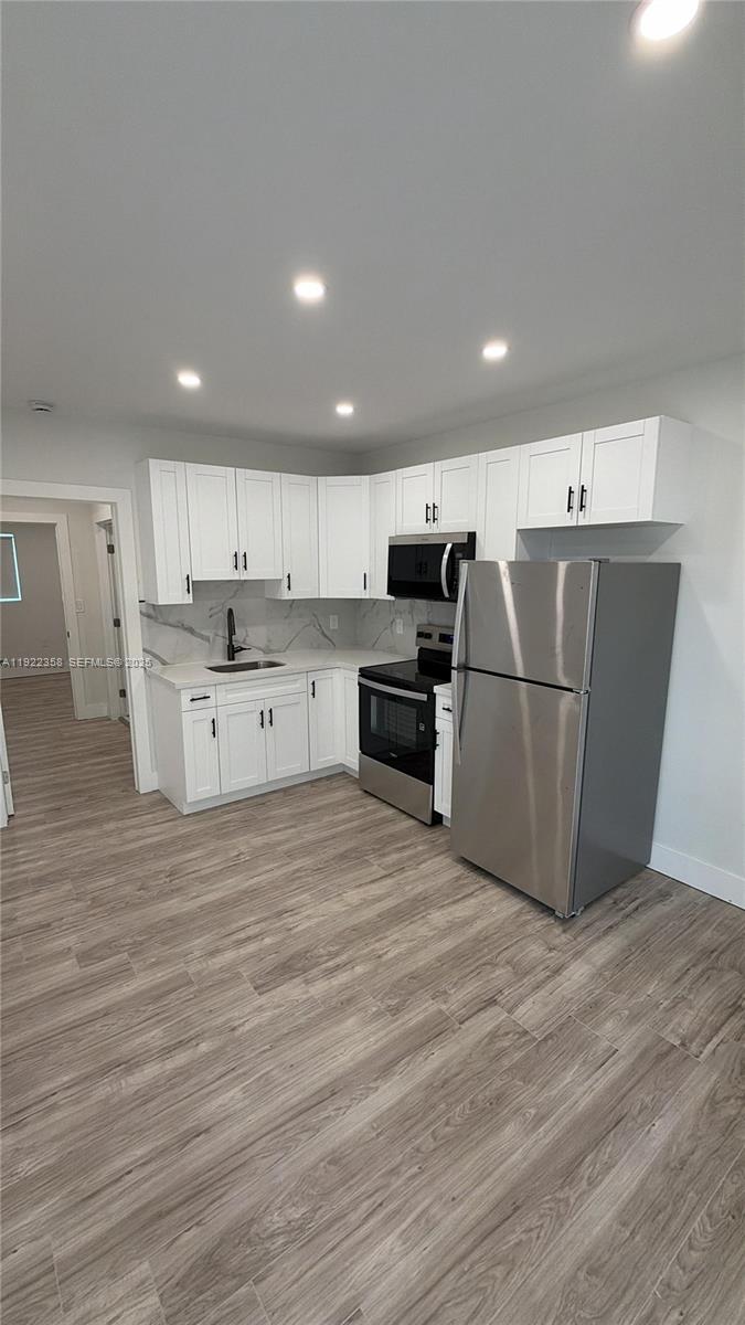 a kitchen with stainless steel appliances granite countertop a refrigerator sink and cabinets