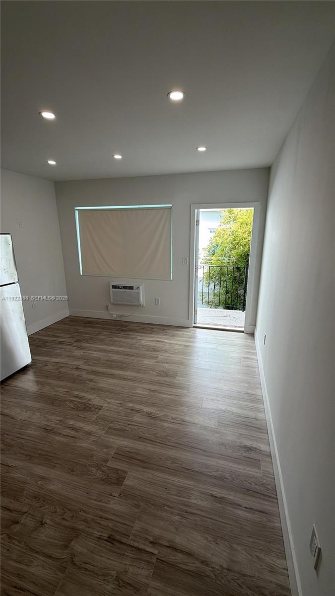 935 Jefferson Avenue, Unit 10 Miami Beach, FL 33139 - Photo 4 of 11 an empty room with wooden floor and windows