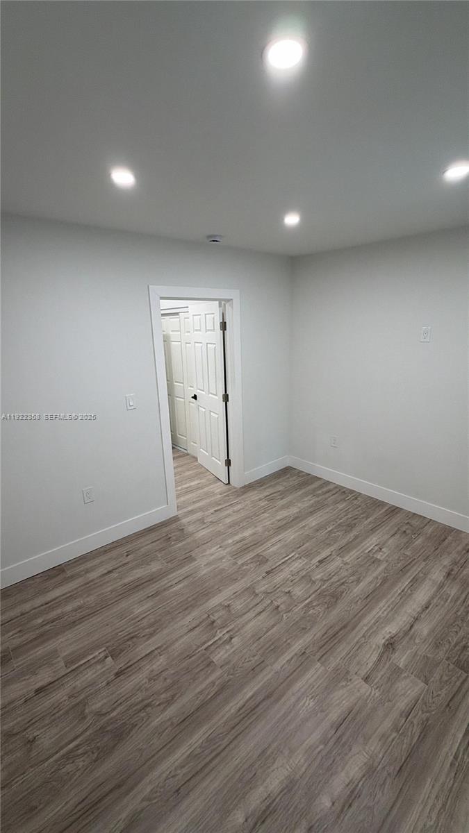 935 Jefferson Avenue, Unit 10 Miami Beach, FL 33139 - Photo 7 of 11 an empty room with wooden floor and windows