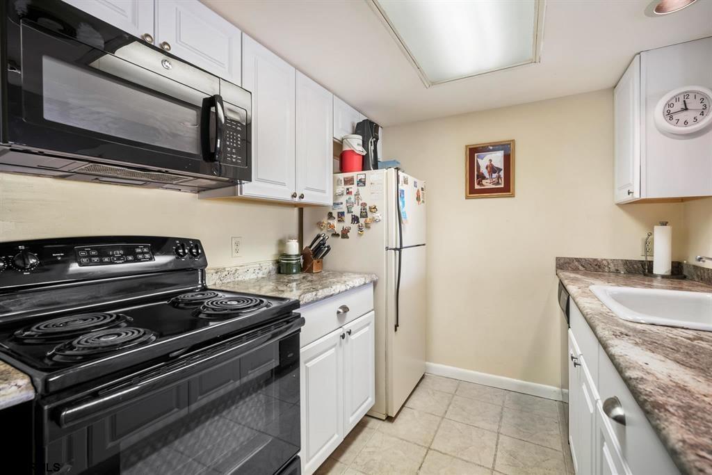 4500 West Brigantine Avenue, Unit 1314 Brigantine, NJ 08203 - Photo 6 of 11 a kitchen with a stove and a microwave
