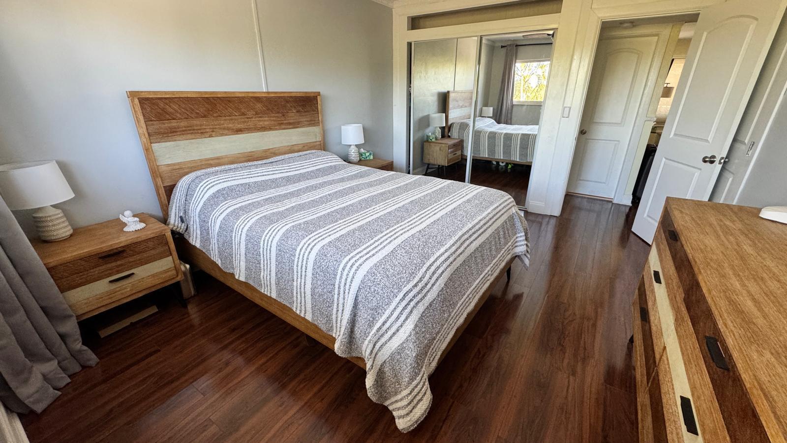 2151 Northeast 42nd Court, Unit 221 Lighthouse Point, FL 33064 - Photo 11 of 31 a bedroom with a bed and wooden floor