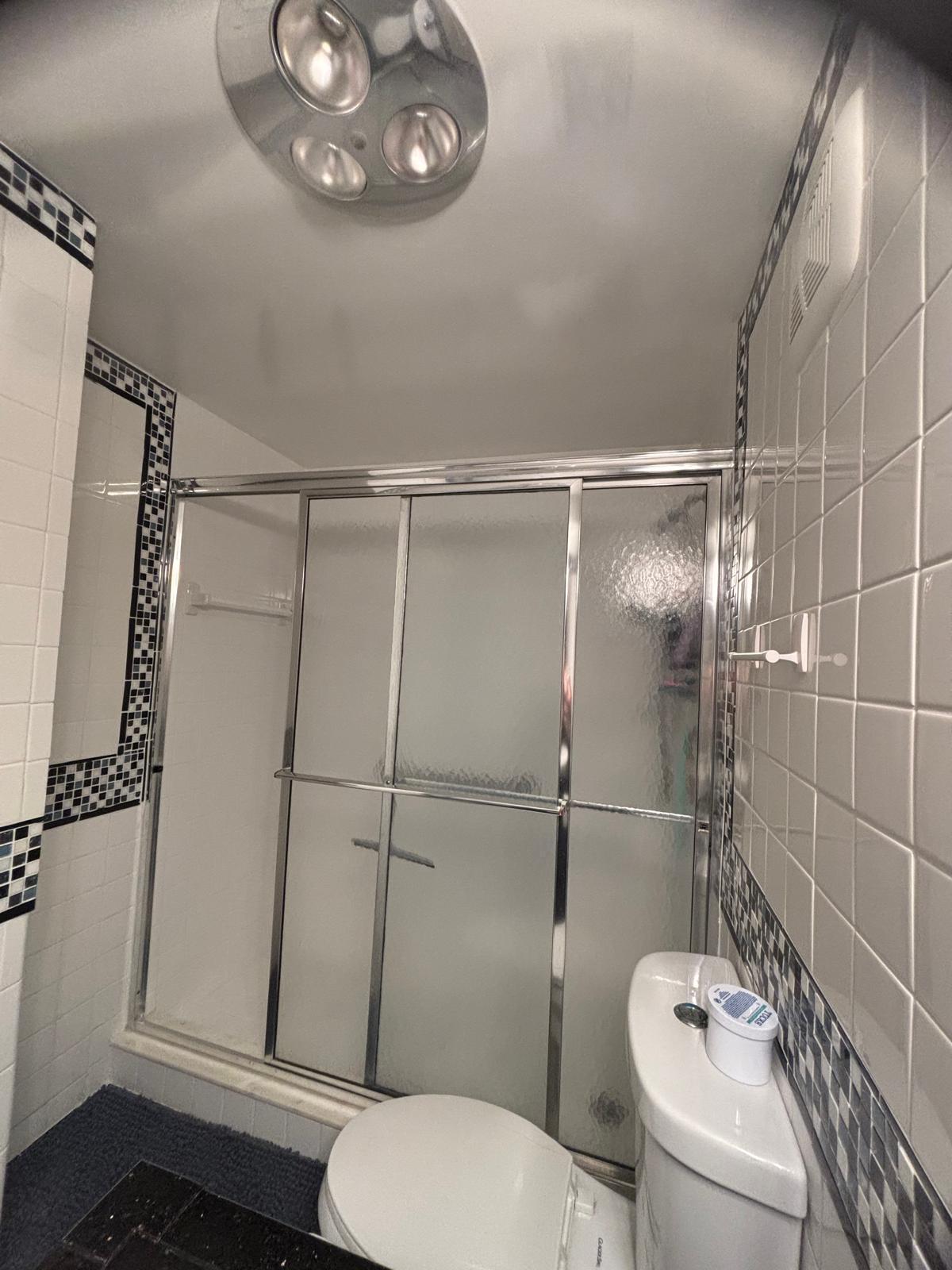 2151 Northeast 42nd Court, Unit 221 Lighthouse Point, FL 33064 - Photo 14 of 31 a white toilet sitting next to a bathroom sink and a shower