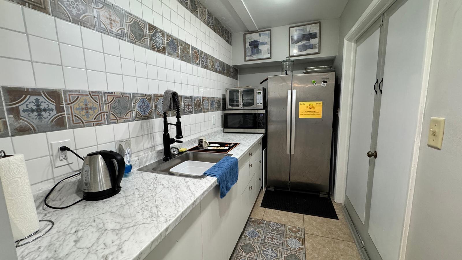 2151 Northeast 42nd Court, Unit 221 Lighthouse Point, FL 33064 - Photo 29 of 31 a kitchen with stainless steel appliances kitchen island granite countertop a refrigerator and a sink