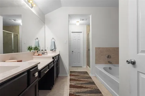 a spacious bathroom with a granite countertop tub sink and mirror